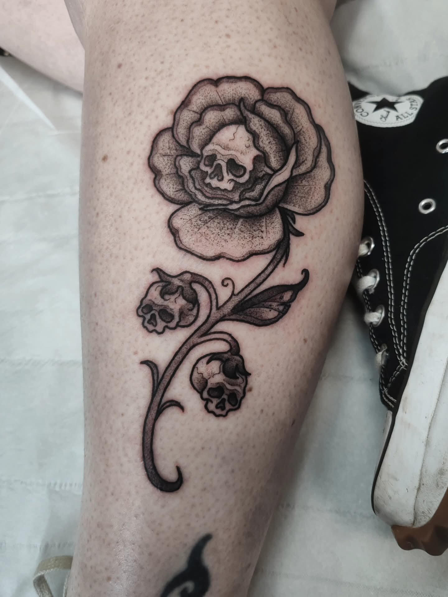 Blackwork gothic tattoo of a flower with a skull in it's centre