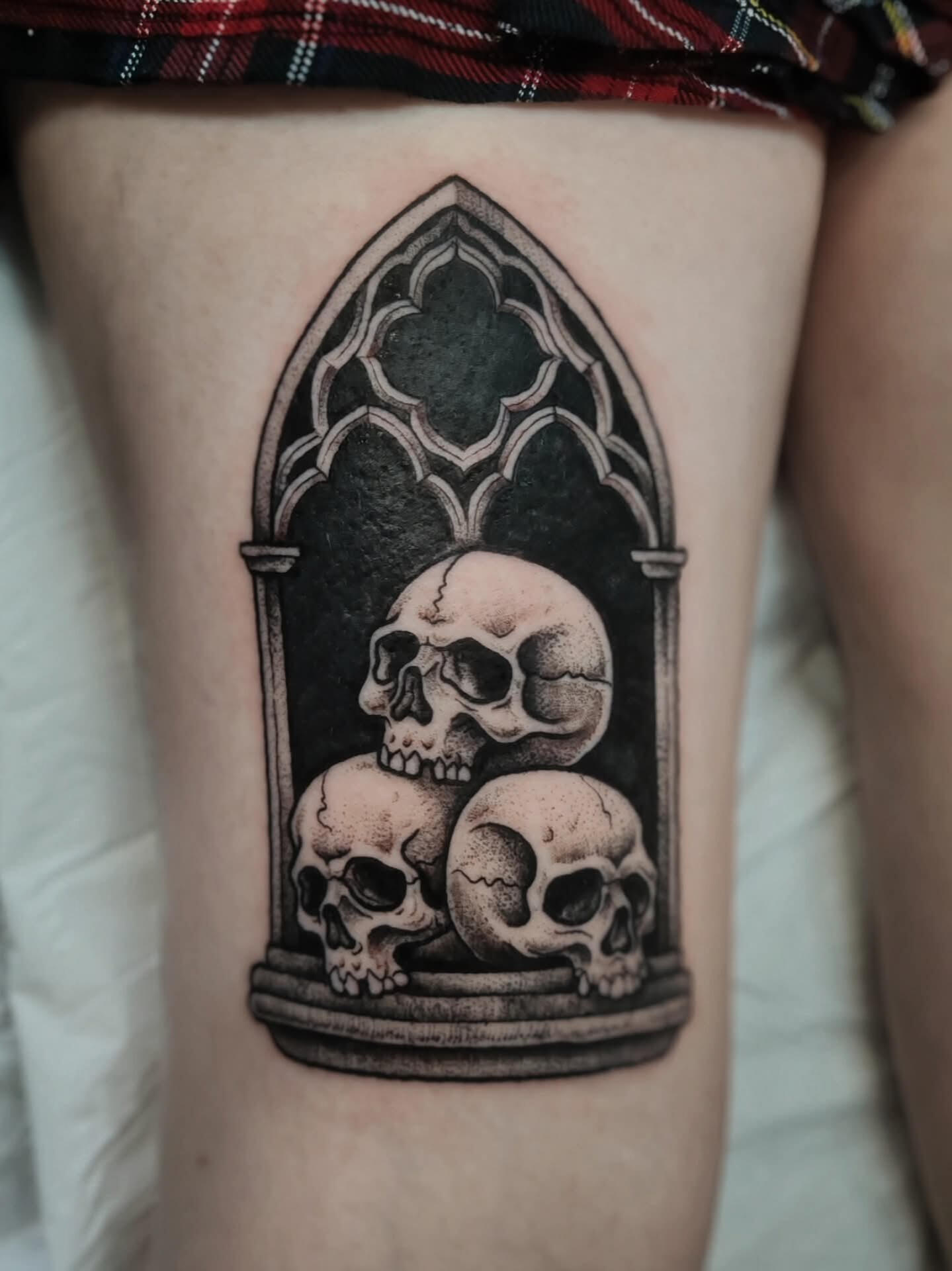 Blackwork gothic window tattoo with skulls